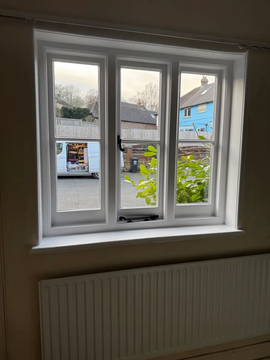 Restored three-light white timber casement window viewed from interior above radiator